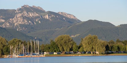 Campingplätze - Segel- und Surfmöglichkeit - Bayern - Der Campingplatz vom See aus mit der Kampenwand im Hintergrund - Chiemsee-Camping Rödlgries