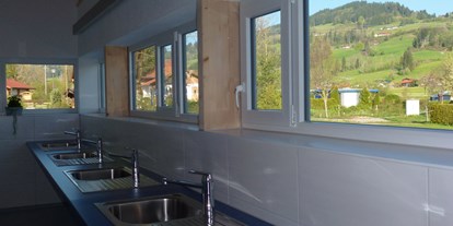 Campingplätze - Kochmöglichkeit - Der Spülbereich mit Panoramablick auf den Stoffelberg.  - Camping Zeh am See/ Allgäu