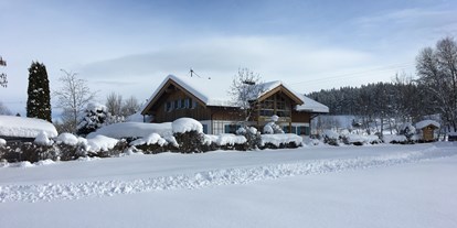 Campingplätze - Liegt in den Bergen - Deutschland - Die Aussicht von der Langlaufloipe auf die verschneite Campingplatzanlage.  - Camping Zeh am See/ Allgäu