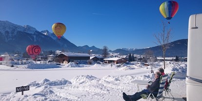 Campingplätze - Wintercamping - Panoramaplatz mit Blick auf die Berge im Winter während der Ballonwoche  - Camping Lindlbauer