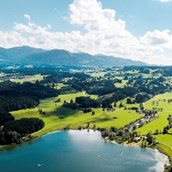 Campingplätze: Luftaufnahme vom Camping Zeh am See mit dem Niedersonthofener See und den Allgäuer Alpen im Hintergrund. - Camping Zeh am See/ Allgäu