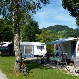Campingplatz: Unsere Wohnwagenstellplätze mit dem Stoffelberg im Hintergrund. - Camping Zeh am See/ Allgäu